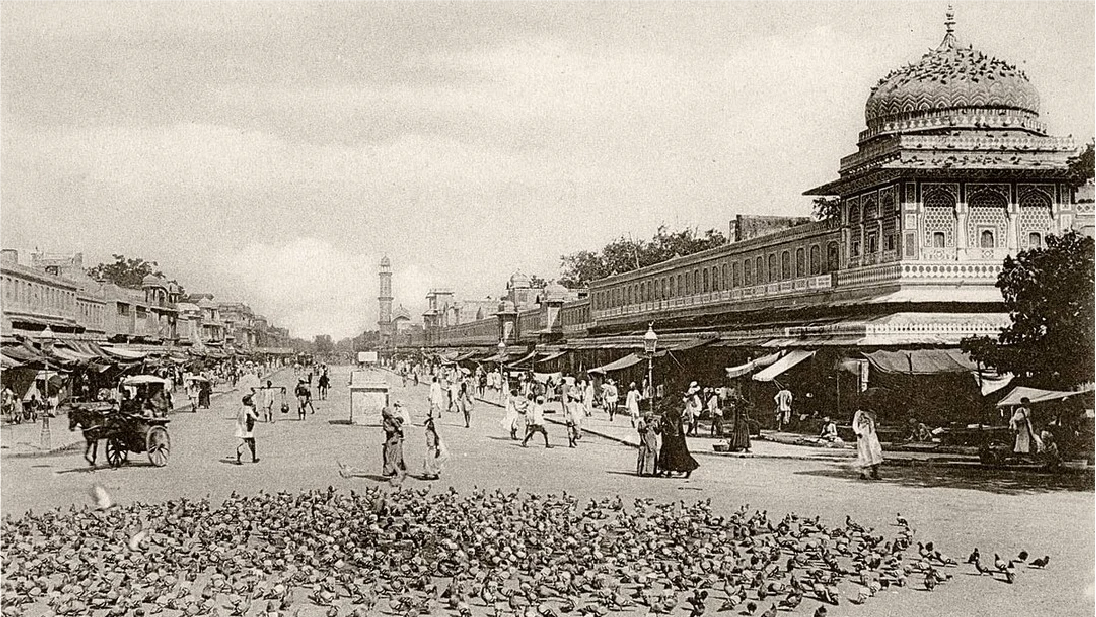 Vintage photograph of a bustling street scene with pigeons in the foreground in Jaipur, India.